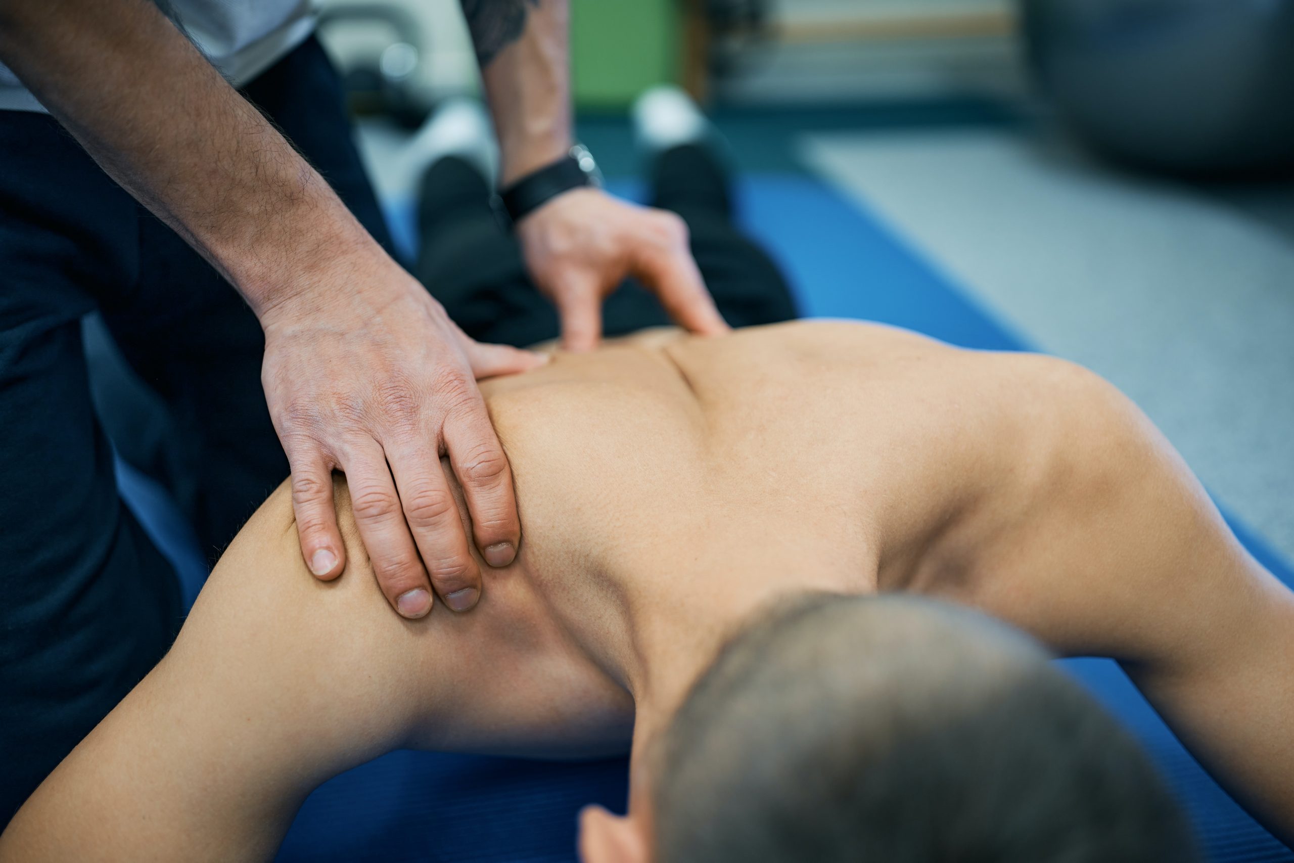 a young male receives a back massage, focusing on upper body tension relief.